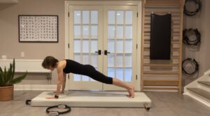 Woman doing plank position on pilates mat