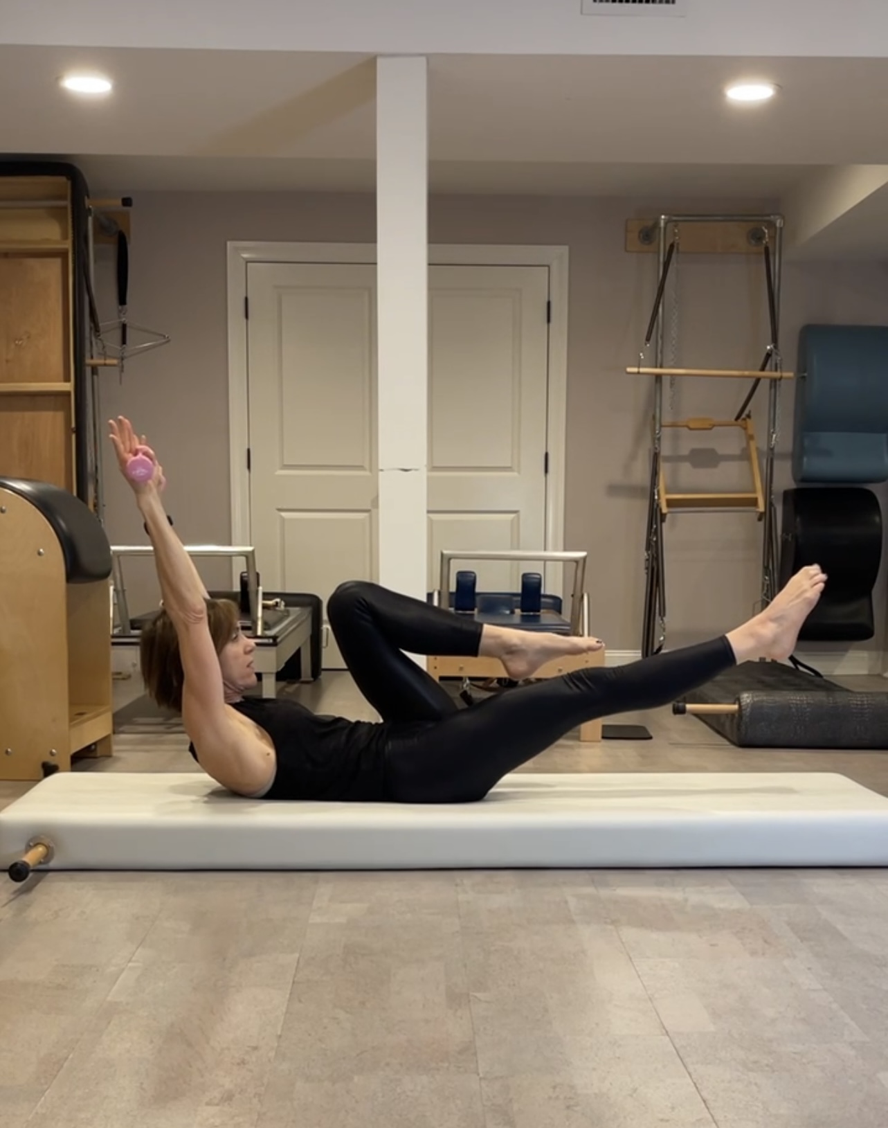 Pilates move on back with hand in the air